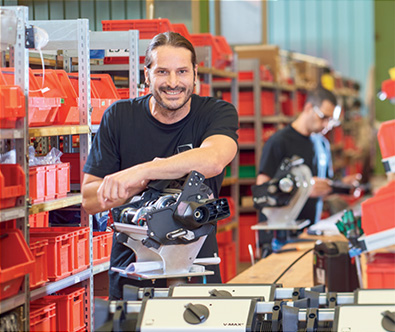 Lagerlogistiker vor dem Auftragsabwicklungsregal der Firma AAT Alber Antriebstechnik GmbH
