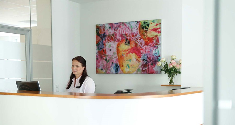 Eine Empfangsdame an einem Empfangstresen.